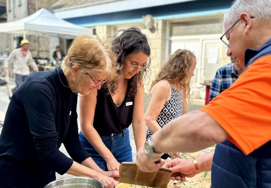 deux femmes et un homme préparent des champignons et des radis pour le disco soupe.