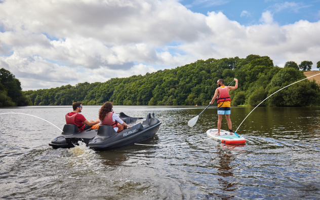 adultes faisant du pédalo et du stand up paddle